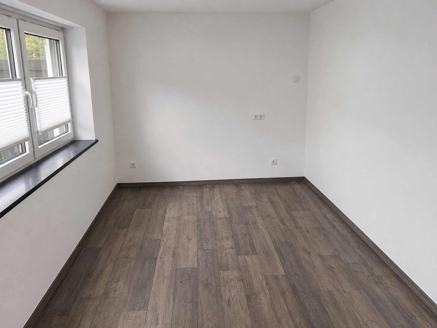 Leerer heller Praxisraum mit großem Fenster und modernem Boden
